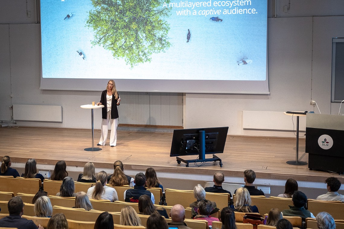 En kvinna föreläser framför publik