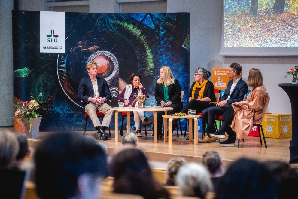 Bild på paneldiskussion på scen med sex personer.